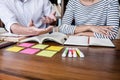 Education, teaching, learning concept. Two high school students or classmates group sitting in library with helps friend doing Royalty Free Stock Photo