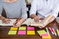 Education, teaching, learning concept. Two high school students or classmates group sitting in library with helps friend doing Royalty Free Stock Photo