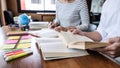 Education, teaching, learning concept. Two high school students or classmates group sitting in library with helps friend doing Royalty Free Stock Photo