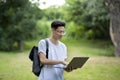 Education And Technology. Male Asian Student Using Laptop Outdoors At Campus