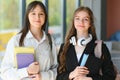 Education. Two clever modern students in black and white uniform study in a library sitting at a table with books