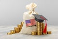 Education in the USA. Concept for expensive education in America. Day bag with a furnace of gold coins with a graduate