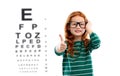 Red haired girl in glasses over eye test chart Royalty Free Stock Photo