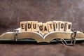 Education word whiten with stamp letters on wood blocks, on a opened book with broken chains, representing education sets you free