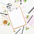 Education workspace composition with clipboard, notebook, flowers and accessories on white background. Flat lay, top view. Royalty Free Stock Photo