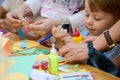 Educational circle for children. Group of nursery children sitting on chairs in their classroom. Male teacher, woman. shows how to