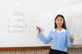 Educational concept a young smart female teacher explaining decision of hard math in a classroom before Covid-19 epidemic Royalty Free Stock Photo