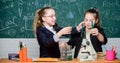 Educational experiment concept. Girls classmates study chemistry. Microscope and test tubes on table. Perform chemical Royalty Free Stock Photo