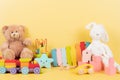 Educational kids toys collection. Teddy bear, train, xylophone, wooden educational baby toys on yellow background. Front Royalty Free Stock Photo