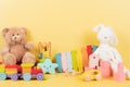 Educational kids toys collection. Teddy bear, train, xylophonr, wooden educational baby toys on yellow background. Front Royalty Free Stock Photo