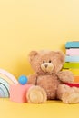 Educational kids toys collection. Teddy bear, wood rainbow, xylophone, wooden educational baby toys on yellow background Royalty Free Stock Photo