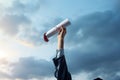 Educational milestone Hand proudly grasping a diploma in the sky