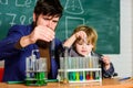 Educational school program. Schoolboy cute child experimenting with liquids. Teacher and child test tubes. School lesson