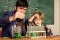 Educational school program. Schoolboy cute child experimenting with liquids. Teacher and child test tubes. School lesson