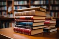 Educational tableau stacked books, blurred library bookshelves, study ambiance