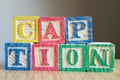 Educational toy cubes with letters organised to display word CAPTION - editing metadata and Search engine optimisation Royalty Free Stock Photo