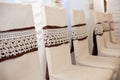 Eelegantly decorated white wedding chairs with brown ribbons at Royalty Free Stock Photo