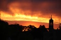 eerie dark orange glow sunrise over city of Worcester Ma with church steeple silhouetted