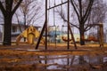 an eerie, empty playground with rusted swings and slide