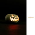 Eerie evening text on white and carved jack o lantern halloween pumpkin on black background