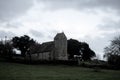 An eerie medieval church on top of a hill. On a bleak moody winters day in the English countryside