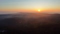 Eerie scenery of golden sunset above clouds over mountains