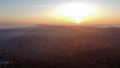 Eerie scenery of golden sunset above clouds over mountains