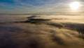 Eerie scenery of sunrise above clouds over mountains