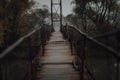 Eerie scenery of a wooden suspension bridge over the river