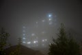 Eerie sky scraper hospital lights shine through very thick fog Royalty Free Stock Photo