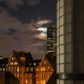 Eery view of moonlit clouds over old redbrick building at night