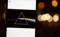 Pink Floyd`s Dark Side of the Moon disc on a mobile phone with defocused Bokeh effect background