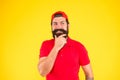 Effective shampoo. Beard and mustache grooming. thinking mature hipster yellow background. bearded man red shirt and cap Royalty Free Stock Photo