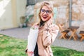 Effective smiling girl in glasses bought tulip bouquet in flower shop for her best friend`s birthday. Lovely young lady Royalty Free Stock Photo