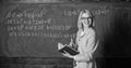 Effective teaching involve acquiring relevant knowledge. Woman teaching near chalkboard in classroom. Qualities that Royalty Free Stock Photo