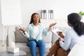 Effective therapy. Happy young black woman having session with psychologist, grateful for professional help at office Royalty Free Stock Photo