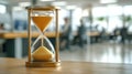 Effective time management represented by an hourglass in modern office environment during working hours. An hourglass Royalty Free Stock Photo