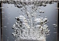 Bubbles rising in a clear liquid, likely water, with numerous small and Royalty Free Stock Photo