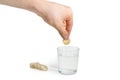 Effervescent medicinal tablet in hand over a glass of water Royalty Free Stock Photo