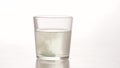 An effervescent tablet with an analgesic effect is thrown into a transparent glass of water. Medicinal quick-acting