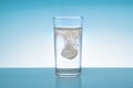 Effervescent tablet dissolves in water glass. Closeup of painkiller tablet in glass of water. Medical conzept Royalty Free Stock Photo