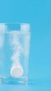 Effervescent tablet dissolving in clear water, creating bubbles and fizz Royalty Free Stock Photo