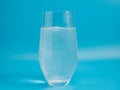 Effervescent tablet in a glass of water close-up on a blue background. Royalty Free Stock Photo