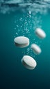 Effervescent tablets dissolving in blue water creating bubbles Royalty Free Stock Photo
