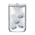 Effervescent tablets dissolving in a glass of water Royalty Free Stock Photo