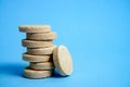 Effervescent tablets tower closeup on blue background, selective focus. Medical concept.