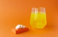 Effervescent vitamins, water-soluble tablets on orange background.