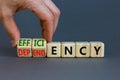 Efficiency or dependency symbol. Businessman turns cubes, changes the word dependency to efficiency. Beautiful grey table, grey