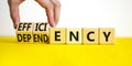 Efficiency or dependency symbol. Businessman turns cubes, changes the word dependency to efficiency. Beautiful yellow table, white
