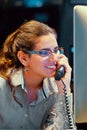 Efficient secretary working in the office and answering phone calls. Customer service concept. Night time Royalty Free Stock Photo